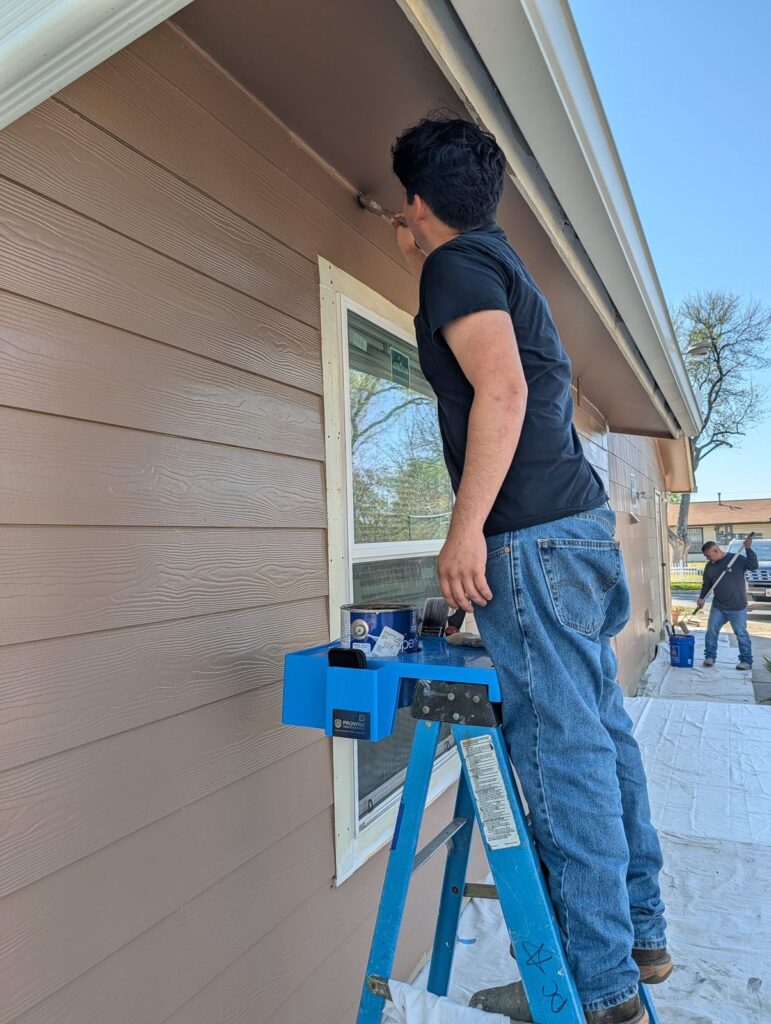 Painter reaching up to an eave while the P3Hpro holds his paint can on the ladder