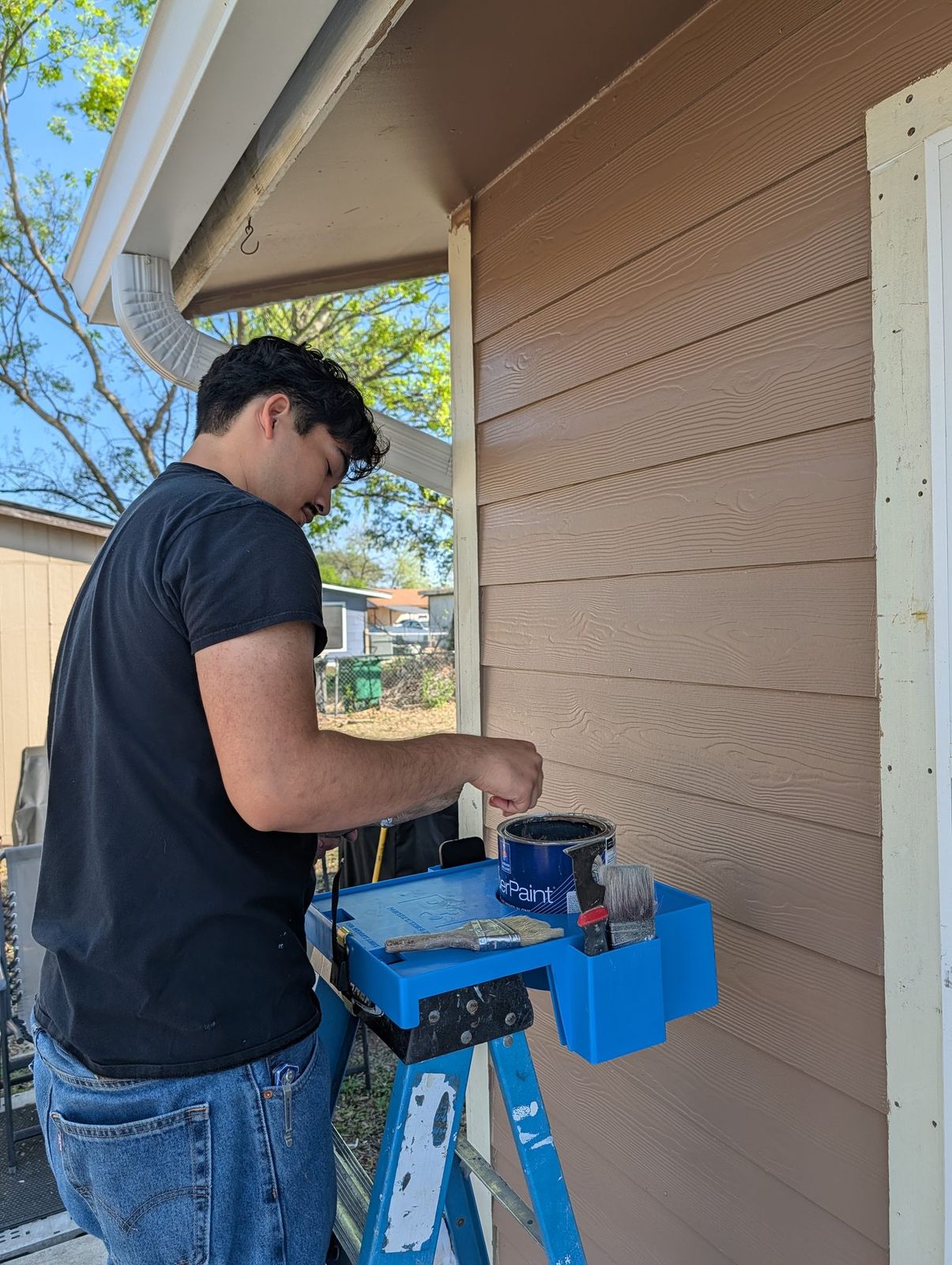 Painter dipping a brush into a paint can held in the P3Hpro on his step ladder
